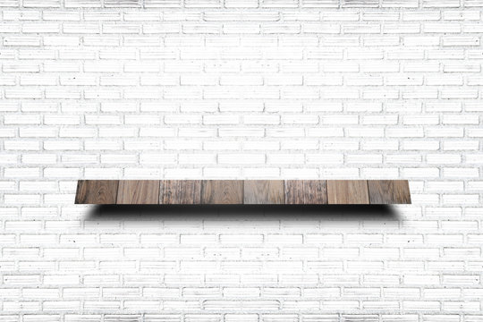 Empty wooden shelf on old white brick wall texture. For display products.