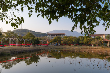 In the park under the setting sun, the lake reflects the scenery by the lake