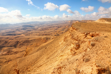 Fototapeta na wymiar Stone desert of Negev. National geological park HaMakhtesh HaGadol. Large Crater - geological erosional land form. It has steep walls of resistant rock surrounding a deep closed valley. Israel