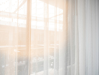 The bedroom in the city in the morning sunshine through the white curtains, giving a feeling of happiness, freshness, and warmth.