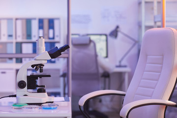 Horizontal no people shot of modern medical laboratory room work space interior in purple light