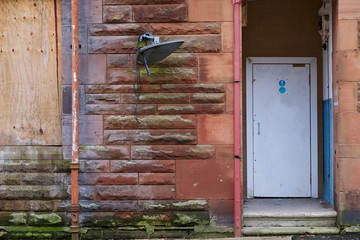 Derelict council house doorway in poor housing  estate slum with many social welfare issues in England UK