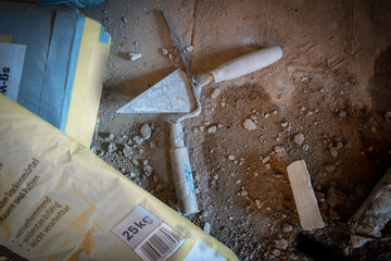 at the bottom of a building site there are two mortar spatulas next to each other