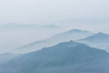 Obraz premium The hazy scenery of the mountain peak filled with clouds