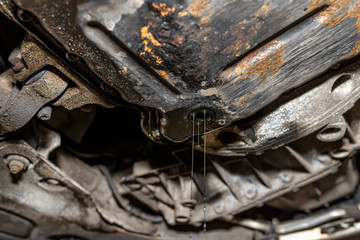 The unscrewed screw at the bottom of the oil pan in the diesel engine through which the rest of the used engine oil flows out.