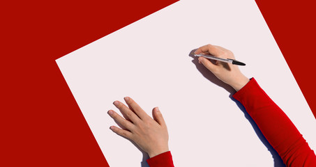 Person writing something with a pen from above