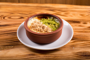 turkish milk dessert on wooden plate in white plate