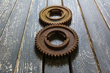 Old rusty gears on a wooden table set in the shape of number eight.