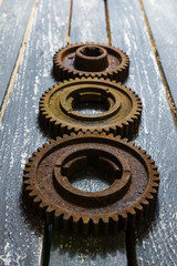 Fototapeta premium Old rusty gears from machines on a wooden table.