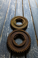 Old rusty gears on a wooden table set in the shape of number eight.