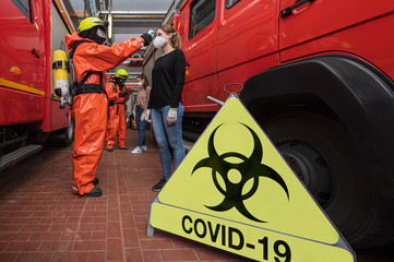 Corona Virus Pandemie ist ausgebrochen. Feuerwehrleute in Seuchenschutzausrüstung und medizinische...