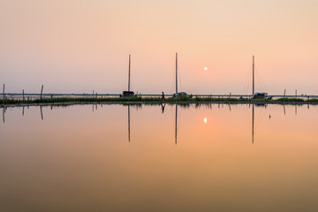 The sunrise by the sea, the quiet sea reflects the red sky