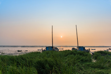 At sunrise on the beach, the masts of the two ships stretched into the sky