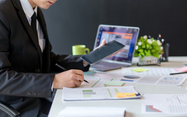 Businessman working at office with documents and graphs with a laptop computer in the office.