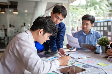 Group of young creative asian business men discussing job offers for the company and planning marketing strategy.