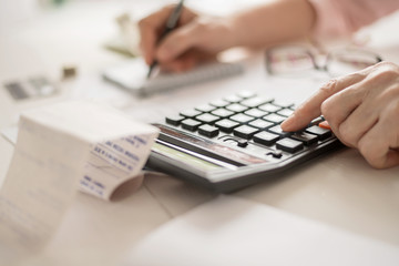 Pension calculation concept, old hands counting finances on a home calculator , close- up
