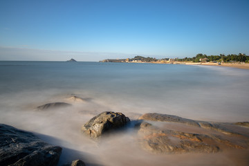The island in the sea, the tide against the reef, the reef appears golden at dusk