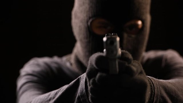 The Robber aiming gun to the victim .