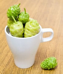 Green Noni or Morinda Citrifolia Fruits in White Cup