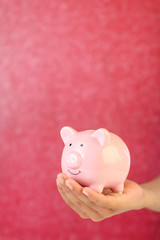 Boy holding piggy bank for savings	
