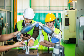 Female and male engineers are inspecting machine operations and controlling product quality.