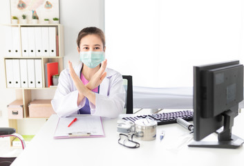 asian female doctor wear surgical mask and show stop sign or cross sign with hand in hospital, she want to pollution protection and virus protection, healthcare and infection control, corona virus