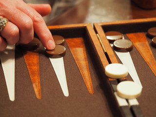Backgammon Board with Man's Hand Moving Pieces