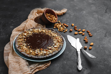 Chocolate cake, chocolate cake, dessert with nuts. Roasted peanuts, almonds and hazelnuts. On dark background. The view from the top. The view from the side. Space for text.