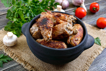Tasty meat rolls with mushrooms in a ceramic pot on a wooden background