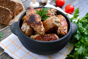 Tasty meat rolls with mushrooms in a ceramic pot on a wooden background