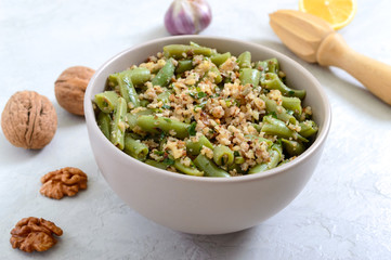 Salad with green beans and spicy walnut sauce in a bowl. Vegetarian, vegan menu