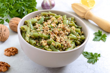 Salad with green beans and spicy walnut sauce in a bowl. Vegetarian, vegan menu