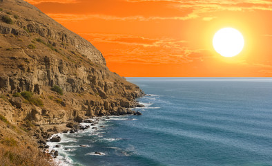 Obrazy  klif morski o czerwonym dramatycznym zachodzie słońca, scena zachodu słońca na morzu