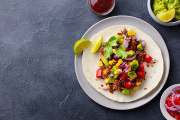 Taco with meat and vegetables. Dark background. Copy space. Top view.