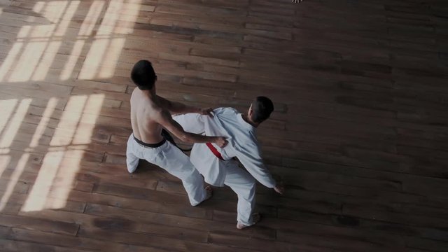 Strong fearless skillful asian guy fighting alone against three powerful warriors in white kimono. He shows active combat tricks and makes forceful attack. Slow motion and rapid.