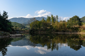 Under the blue sky, the rural lake reflects the landscape