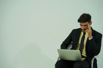 portrait of caucasian young businessman wearing suit with the mobile phone and computer looked at the camera to have the teleconference with the office meeting  work from home during virus pandemic