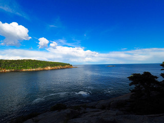 Ocean with blue skies and clouds reflected