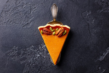 Pumpkin pie, cake piece. Black slate background. Copy space. Top view.