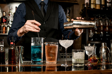 Professional bartender pounds cocktails at the bar.