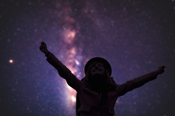 Fototapeta na wymiar Woman enjoying starry night with arms wide open.