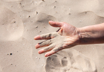 Woman shows the sand on the hand