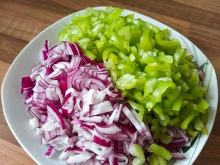 Sliced red onion and green peppers, kitchen food background.
