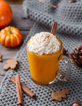 Pumpkin latte with spices. Boozy cocktail with whipped cream. Grey background.