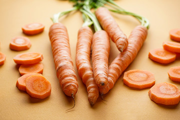 Ripe fresh carrots on a brown background. Close-up.