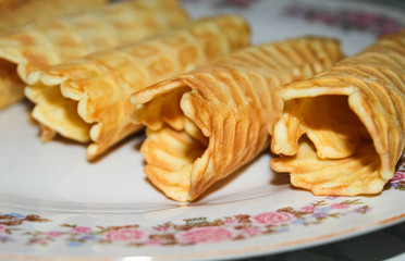 Sweet pastry tubes are stacked on top of each other. Baked confectionery. Delicious dessert.