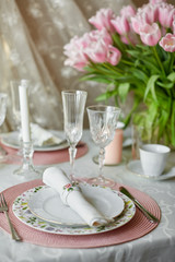 Decor and spring table setting is a vase with pink tulips