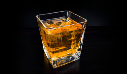 Glass of brandy on black background