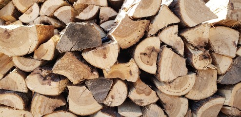 Fototapeta premium Background of dry chopped firewood logs piled up