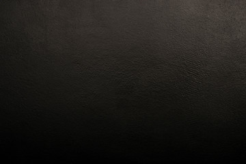 Textural black wall. Black background with a clearly visible texture. Dark background, abstraction,...
